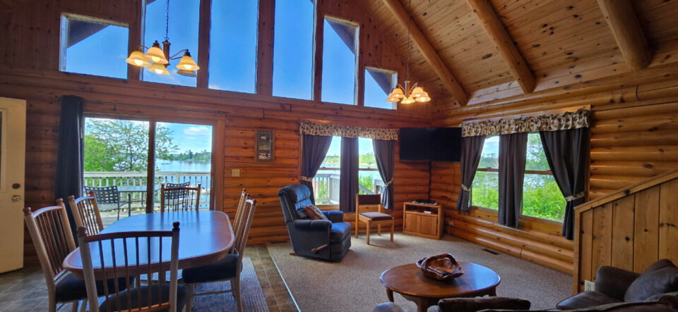Cozy log cabin interior with lake view and vaulted ceiling