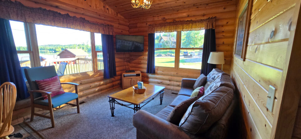 Cozy log cabin living room with lake view windows